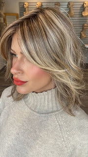 Madeline wearing CYRUS by BELLETRESS in BROWN SUGAR BLONDE-R | A warm, dimensional blend of medium brown and golden blonde highlights with natural-looking darker roots for depth and a sun-kissed finish.