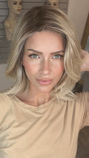 Madeline wearing FARREN by AMORE in MELTED-SAND | Rich, warm brown root melts into the neutral blond tone. Light-beige blond ends complete this stunning color.