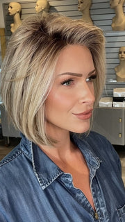 Madeline wearing BECKHAM by BELLETRESS in BUTTERCAKE BLONDE-R | A neutral-warm blonde blend featuring light brown, ash, and lightest blonde tones with natural-looking darker roots for added depth and realism.