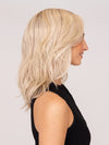 Model is wearing DAZZLING WAVEZ by RENE OF PARIS in color MILKY OPAL R | A Blend of Creamy Blonde and White Blonde Rooted with Warm Brown