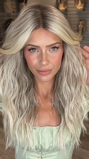 Madeline is wearing ROXIE by RENE OF PARIS in shade BILLIONAIRE-BLOND | A chic, sophisticated shade with a rich mocha root melting into beige, ash, and cream blond tones. Face-framing cream and white blond highlights add a refined, upscale finish.