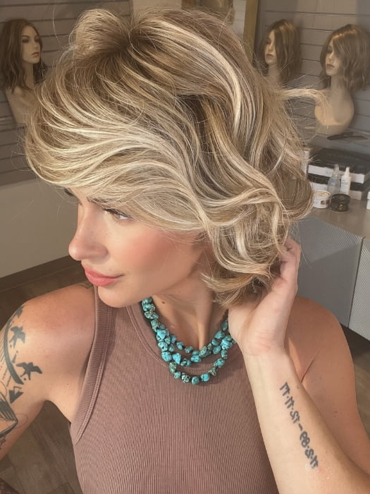 Madeline wearing MONROE by BELLETRESS in BUTTERCAKE BLONDE-R | A neutral-warm blonde blend featuring light brown, ash, and lightest blonde tones with natural-looking darker roots for added depth and realism.
