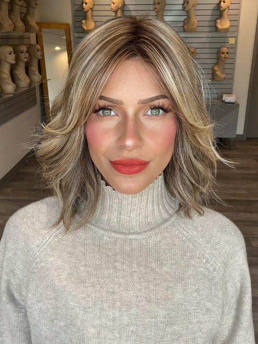 Madeline wearing CYRUS by BELLETRESS in BROWN SUGAR BLONDE-R | A warm, dimensional blend of medium brown and golden blonde highlights with natural-looking darker roots for depth and a sun-kissed finish.