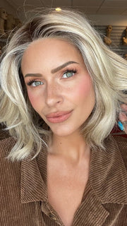 Madeline is wearing MIRA by AMORE in SEA SALT BLOND R | A perfect mixture of cool, icy-blond and warm-dark blond. The rich brown root tone enhances the modern appearance.