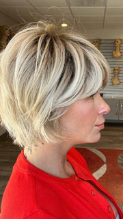 Madeline is wearing TOLEDO by BELLETRESS in CRUSHED ALMOND BLONDE R | A soft Neutral Light Blonde with a Light and Medium Blended Root Color.