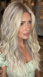Madeline is wearing ROXIE by RENE OF PARIS in shade BILLIONAIRE-BLOND | A chic, sophisticated shade with a rich mocha root melting into beige, ash, and cream blond tones. Face-framing cream and white blond highlights add a refined, upscale finish.