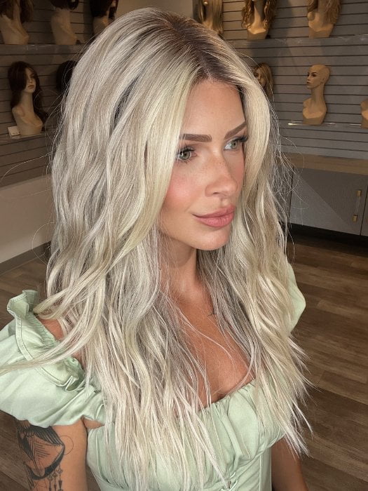Madeline is wearing ROXIE by RENE OF PARIS in shade BILLIONAIRE-BLOND | A chic, sophisticated shade with a rich mocha root melting into beige, ash, and cream blond tones. Face-framing cream and white blond highlights add a refined, upscale finish.
