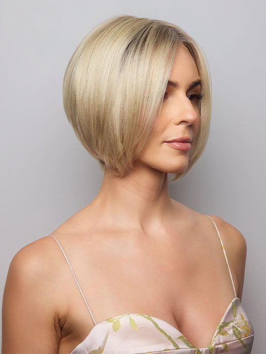 Model is wearing AYUMI by NORIKO in color Light Ash Blond R | Cream Ash Blonde with ash brown and white-grey roots that blend into a variety of ash blonde tones, including ash pearl blonde, creamy ivory, and pale cream