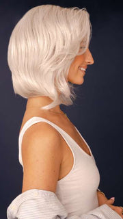 Model is wearing SHEENA by RENE OF PARIS in color GHOST-BLONDE-R | Medium neutral blond roots fade into a pearl cream blond shade with platinum blond undertones.