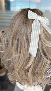 Roxie wearing BROOKLYN by BELLE TRESS in color MILKSHAKE BLONDE R | Mixture of Light sandy brown, highlighted with light ash blonde with a hint of light platinum blonde with medium root color.