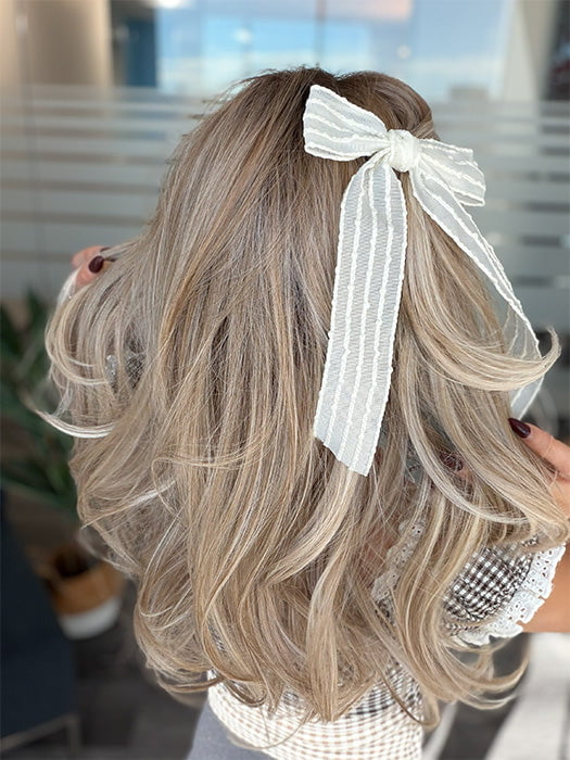 Roxie wearing BROOKLYN by BELLE TRESS in color MILKSHAKE BLONDE R | Mixture of Light sandy brown, highlighted with light ash blonde with a hint of light platinum blonde with medium root color.
