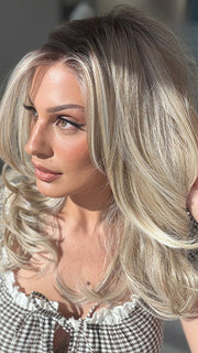 Roxie wearing BROOKLYN by BELLE TRESS in color MILKSHAKE BLONDE R | Mixture of Light sandy brown, highlighted with light ash blonde with a hint of light platinum blonde with medium root color.