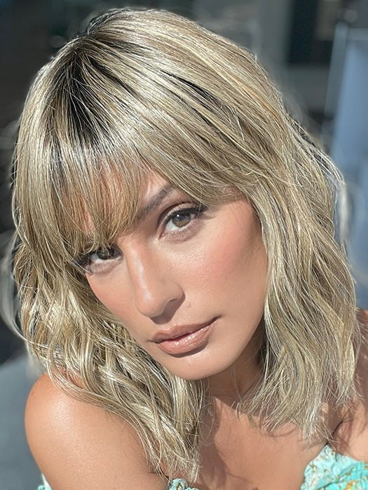 Model is wearing FRANKIE by ESTETICA in color RH12/26RT4 | Light Brown with Fine Golden Blonde Highlights And Dark Roots