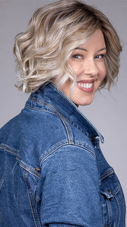 Model is wearing HOUSTON in color MILKSHAKE BLONDE R | A mixture of Light Sandy Brown, Highlighted with Light Ash Blonde with a Hint of Light Platinum Blonde with a Medium Root Color