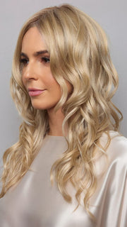Model is wearing HANA by NORIKO in color Light Ash Blond R | Cream Ash Blonde with ash brown and white-grey roots that blend into a variety of ash blonde tones, including ash pearl blonde, creamy ivory, and pale cream