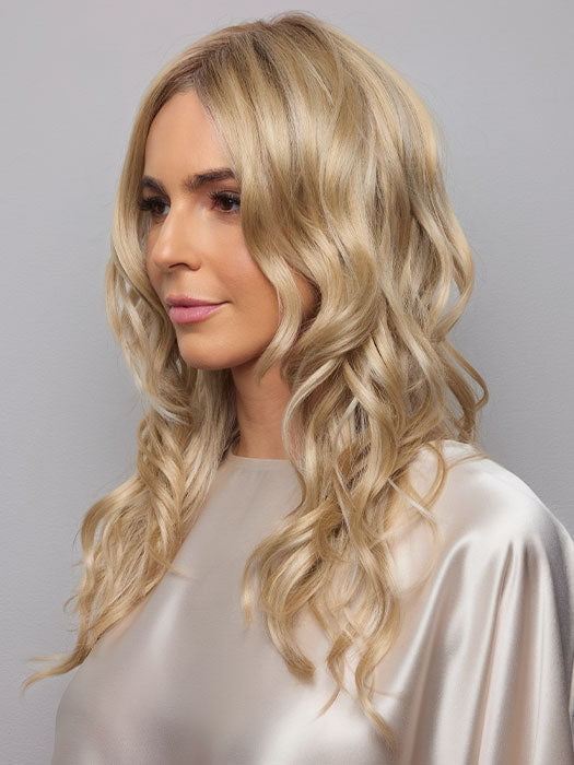 Model is wearing HANA by NORIKO in color Light Ash Blond R | Cream Ash Blonde with ash brown and white-grey roots that blend into a variety of ash blonde tones, including ash pearl blonde, creamy ivory, and pale cream