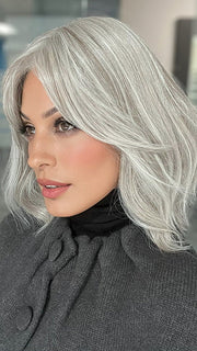 Roxie is wearing HOLLIE PETITE by JON RENAU in shade 56F51 OYSTER | Light Grey with 20% Medium Brown Front, graduating to Grey with 30% Medium Brown Nape 