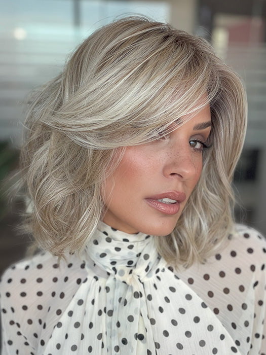 Model is wearing LORYN in color SEA SEA SALT BLOND R | A perfect mixture of cool, icy-blond and warm-dark blond. The rich brown root tone enhances the modern appearance