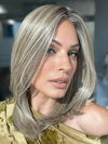 Roxie is wearing OWN THE ROOM LUXURY by GABOR in color GF12-22SS CAPPUCCINO | Light Golden Brown Evenly Blended with Cool Platinum Blonde Highlights with Dark Roots
