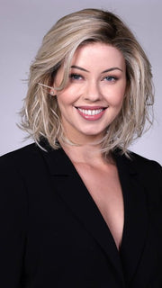 Model is wearing PARK AVE By BELLETRESS in CRUSHED-ALMOND-BLONDE-R | A Soft Neutral Light Blonde with a Light and Medium Blended Root Color