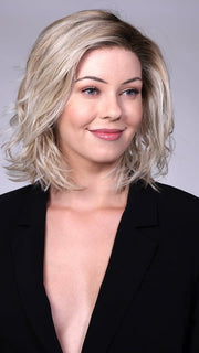 Model is wearing PARK AVE By BELLETRESS in CRUSHED-ALMOND-BLONDE-R | A Soft Neutral Light Blonde with a Light and Medium Blended Root Color