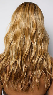 Model is wearing POSH WAVEZ in Bronzed Honey-R  | A perfect blend of rich, warm golden blond and medium chocolate brown tones, complemented by a dark chocolate root that adds a luxurious, dimensional effect.