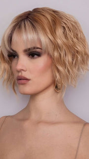 Model is wearing ROSANNA by RENE OF PARIS in color PEACHES AND CREAM | A vibrant peach blonde with creamy undertones and bright, face-framing cream highlights. Rich chocolate root adds depth.
