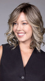 Model is wearing STREEP in SPARKLING CHAMPAGNE BLONDE R | A radiant blend of champagne blonde with soft golden and beige tones, grounded by natural-looking roots in ash brown and dark blonde.
