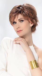 Model is wearing AVENUE SOFT by ELLEN WILLE in color ROSEWOOD LIGHTED | Medium Brown, Caramel, and Rose Gold blend with Highlights Throughout and Concentrated in the Front with Shaded Roots