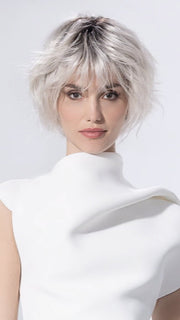 Model is wearing ESCAPE SOFT by ELLEN WILLE in color SILVER BLONDE ROOTED 60.1001.24 | Pearl White and Winter White with Lightest Ash Blonde Blend and Shaded Roots