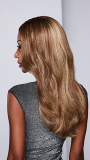 Model is wearing ATHENIAN ADVENTURE by RAQUEL WELCH in color RH9/24SS SHADED CAFE LATTE | Dark Brown with Golden Brown highlights from dark roots to ends