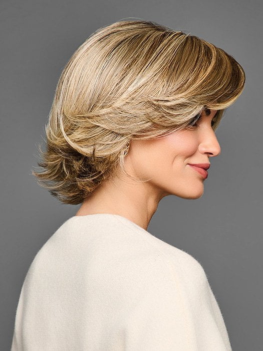 Model is wearing STAND OUT STYLE by GABOR in color GF12-22SS SHADED CAPPUCCINO | Light Golden Brown Evenly Blended with Cool Platinum Blonde Highlights with Dark Roots