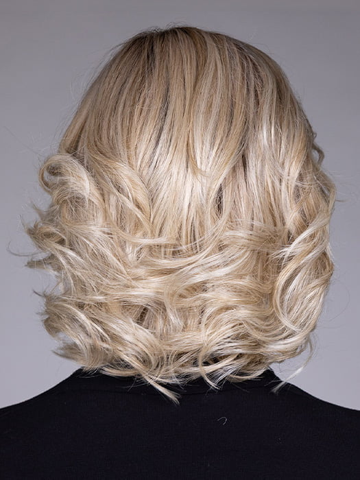 Model is wearing HELSINKI by BELLETRESS in color CRUSHED ALMOND BLONDE R | A soft Neutral Light Blonde with a Light and Medium Blended Root Color.