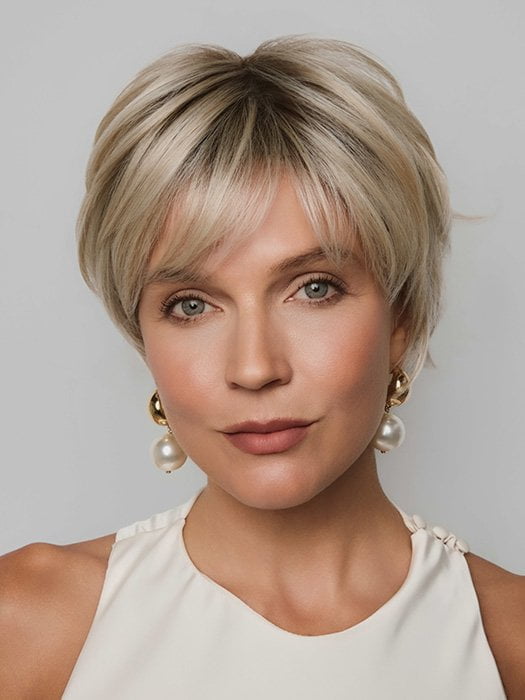 Model is wearing MIO by NORIKO in color SANDY CREAM BLOND R | A blend of beige brown, honey, and creamy blond with subtle roots.
