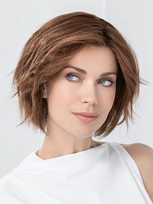 Model is wearing JADORE DELUXE by ELLEN WILLE in color CHOCOLATE-ROOTED | Medium to Dark Brown base with Light Reddish Brown highlights and Dark Roots