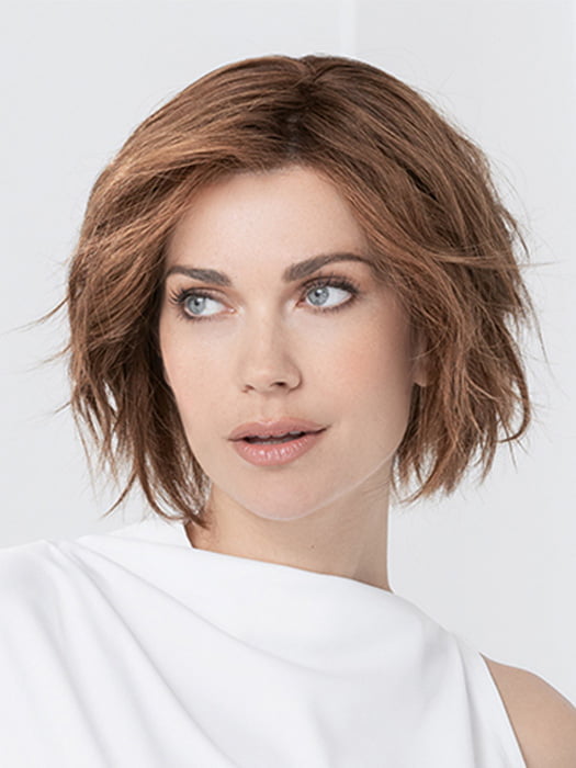 Model is wearing JADORE DELUXE by ELLEN WILLE in color CHOCOLATE-ROOTED | Medium to Dark Brown base with Light Reddish Brown highlights and Dark Roots
