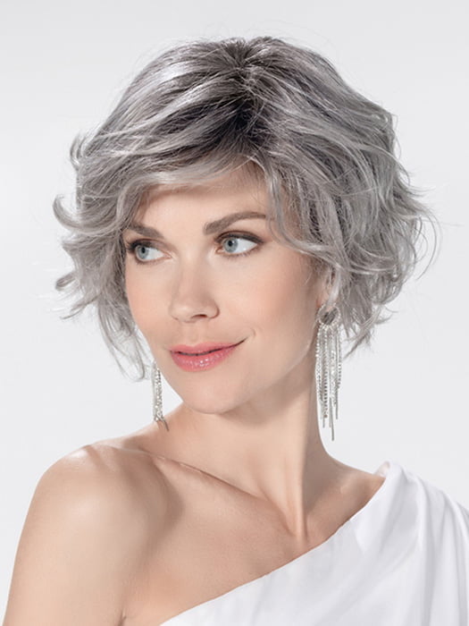 Model is wearing ROMANCE DELUXE by ELLEN WILLE in color METALLIC GREY ROOTED 60.51 | Pearl White, Darkest/Lightest Brown with Grey Blend with Shaded Roots