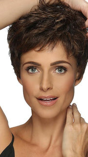 A full-bodied pixie style with curls, wispy bangs & tapered nape